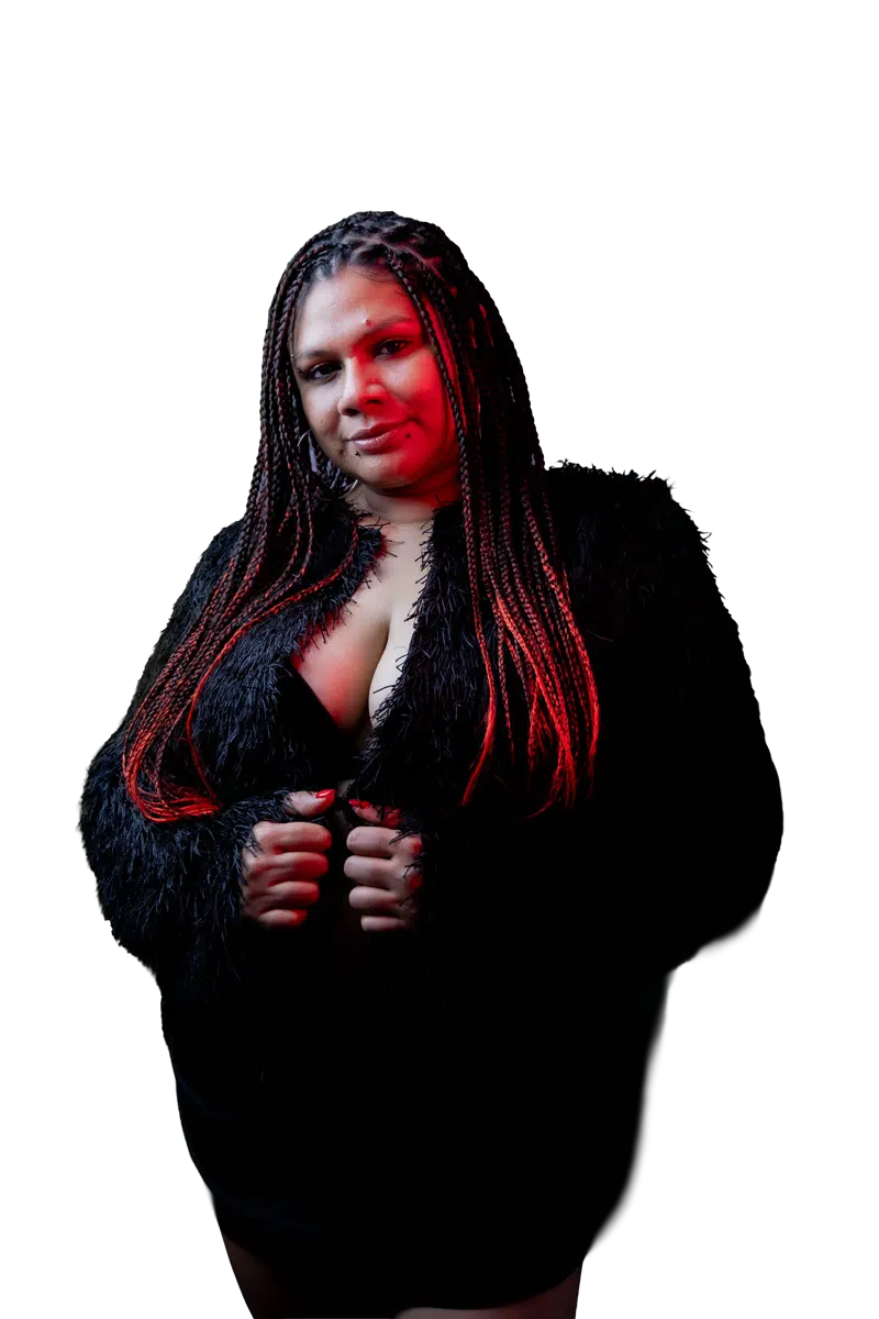 DJ Kim facing the camera in a black outfit under red edge lighting