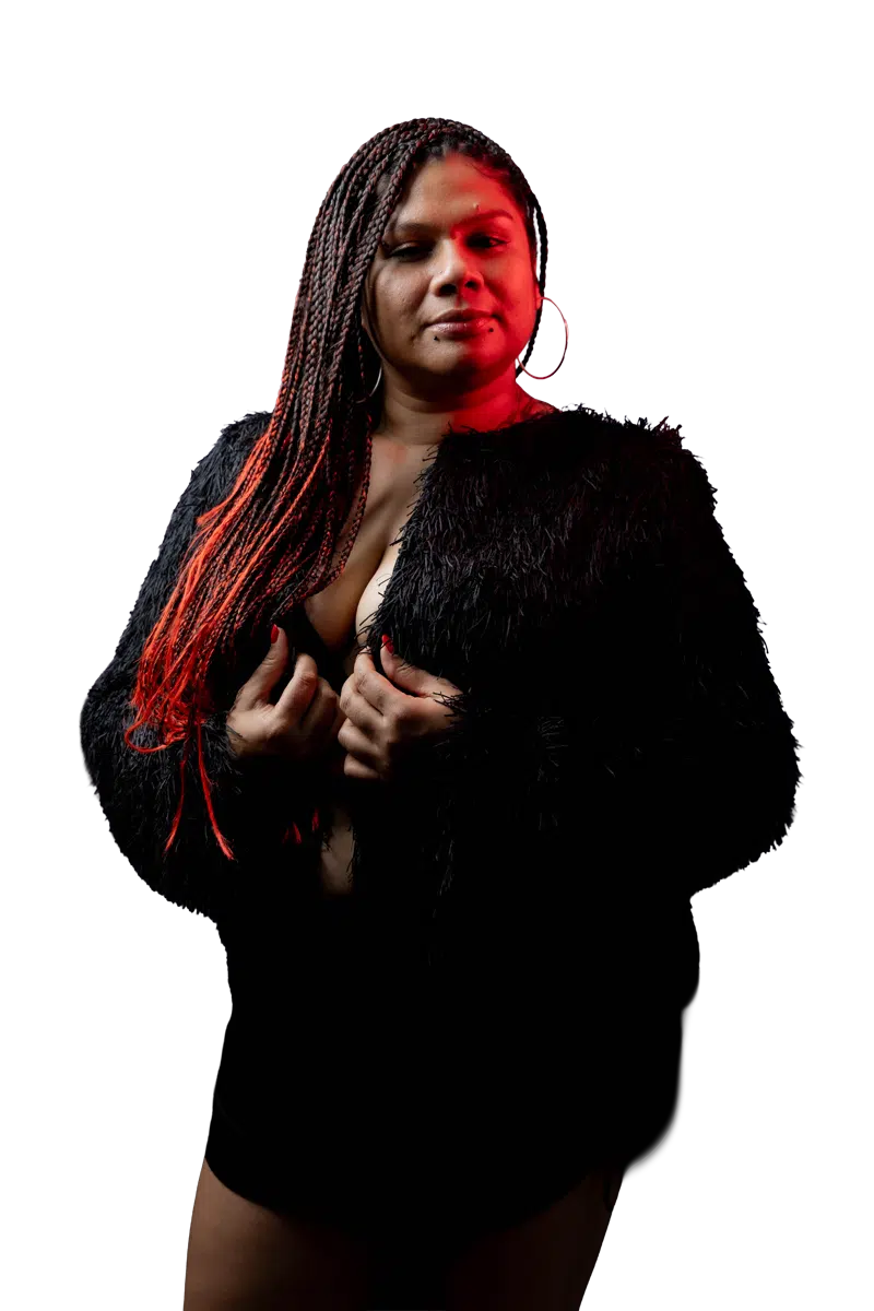 Full-length portrait of DJ Kim in black with red light on her braids