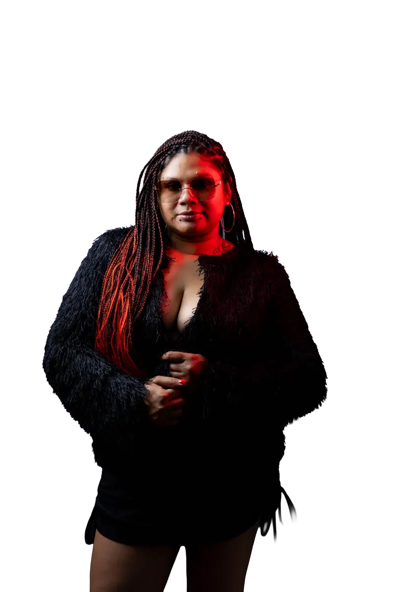 DJ Kim standing front and centre in a black studio portrait
