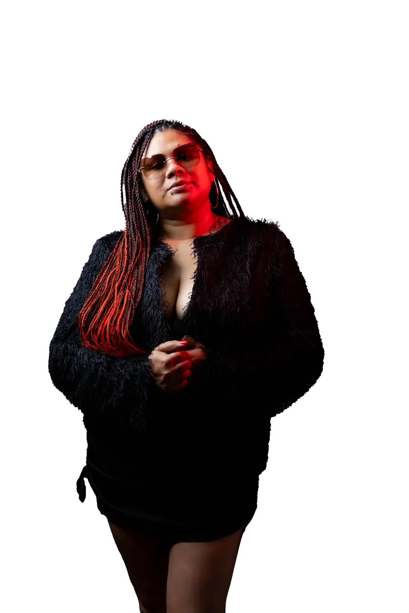 DJ Kim wearing sunglasses in a full-length black studio portrait