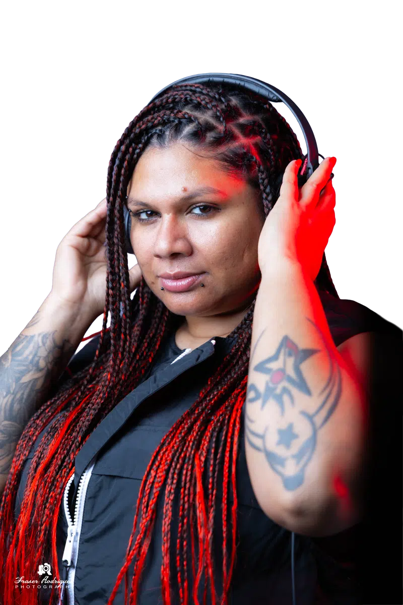 Close-up portrait of DJ Kim wearing headphones under red studio light