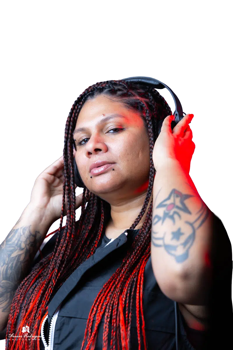 Close-up of DJ Kim listening through headphones with one hand raised